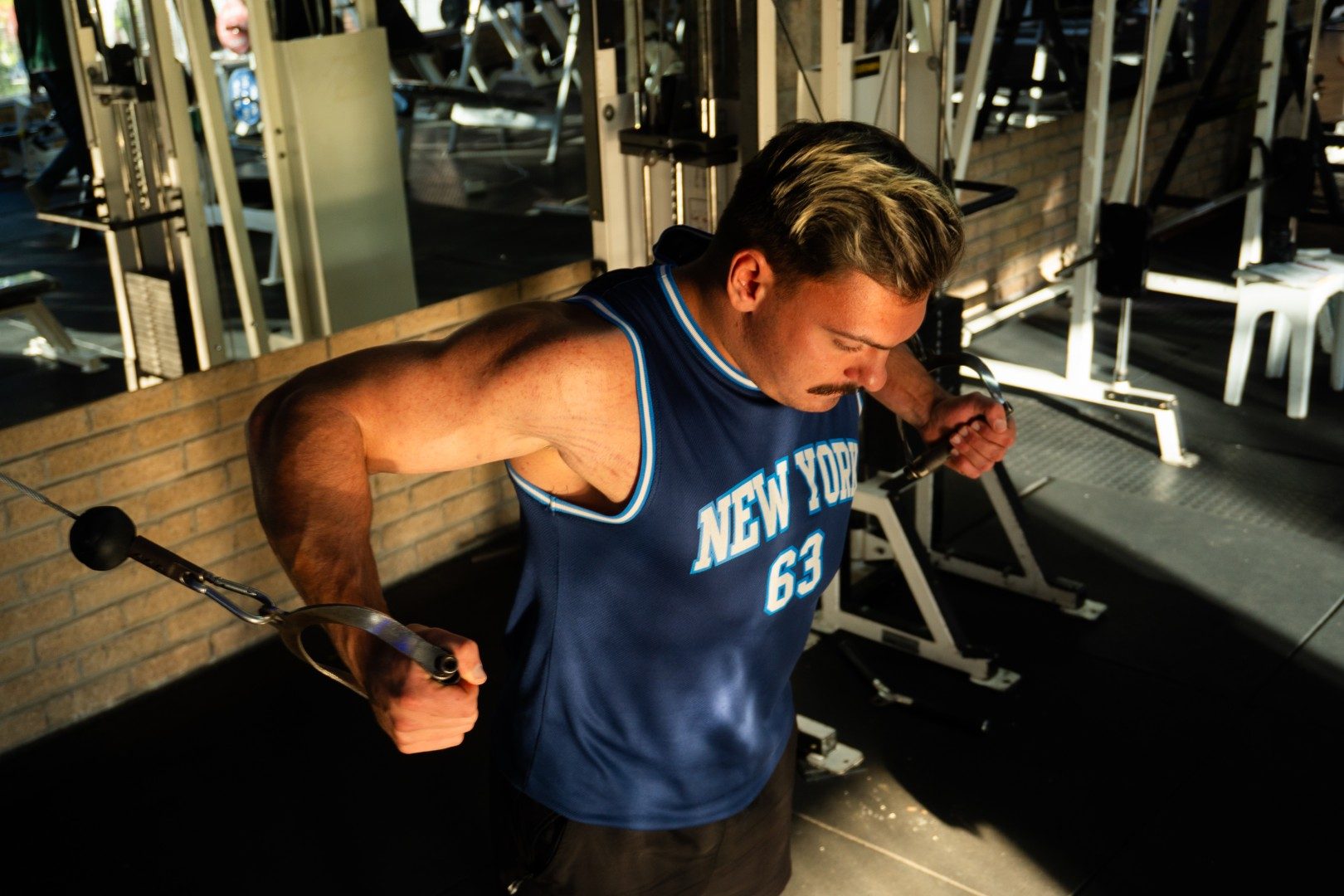 Gym member performing cable crossover exercise at Oxigim