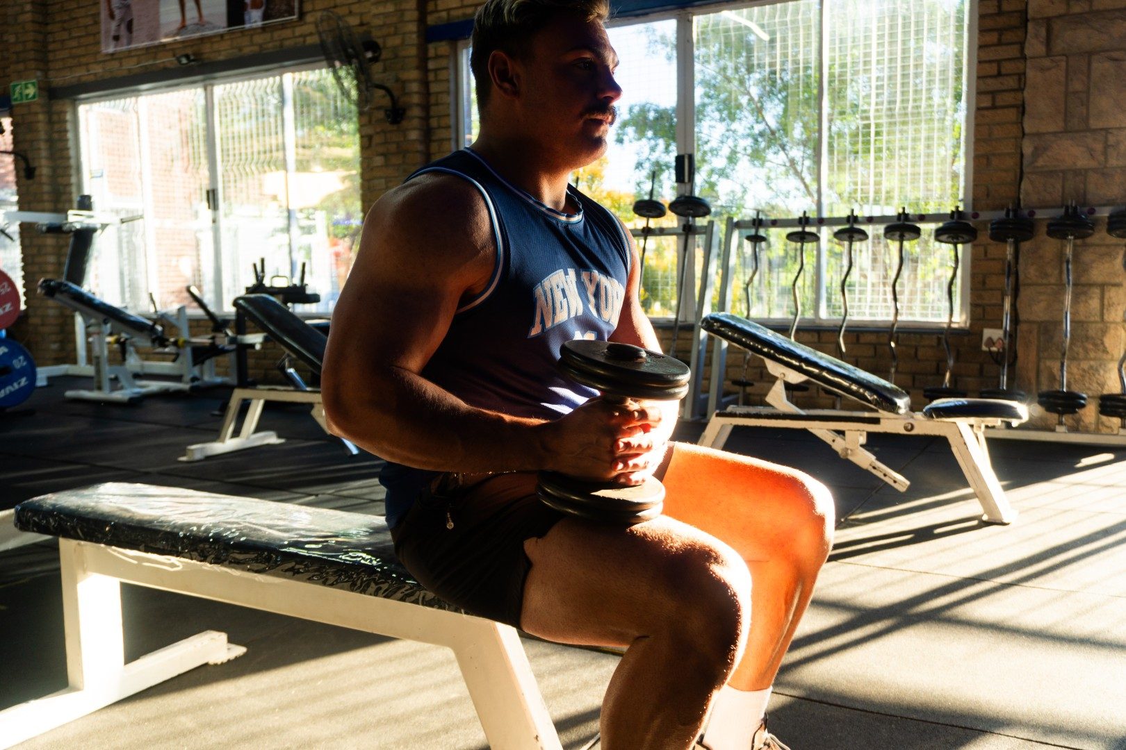 Athlete seated with dumbbell curl at Oxigim Oudtshoorn