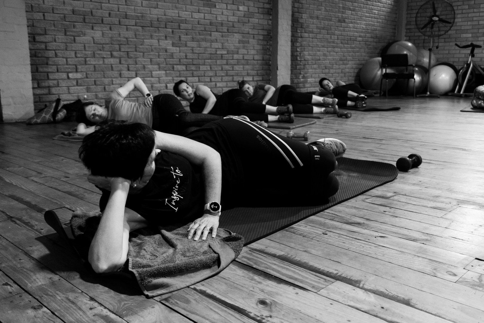 Group fitness class at Oxigim doing floor exercises