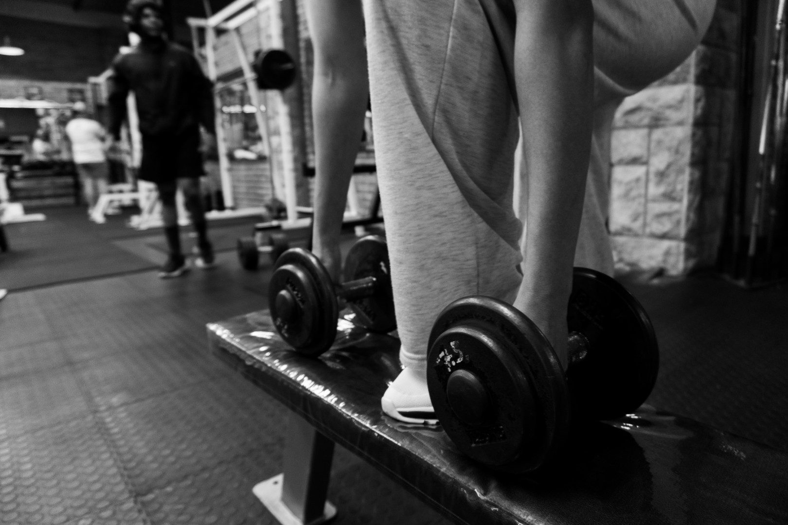 Female member doing lateral raise with dumbbells at Oxigim