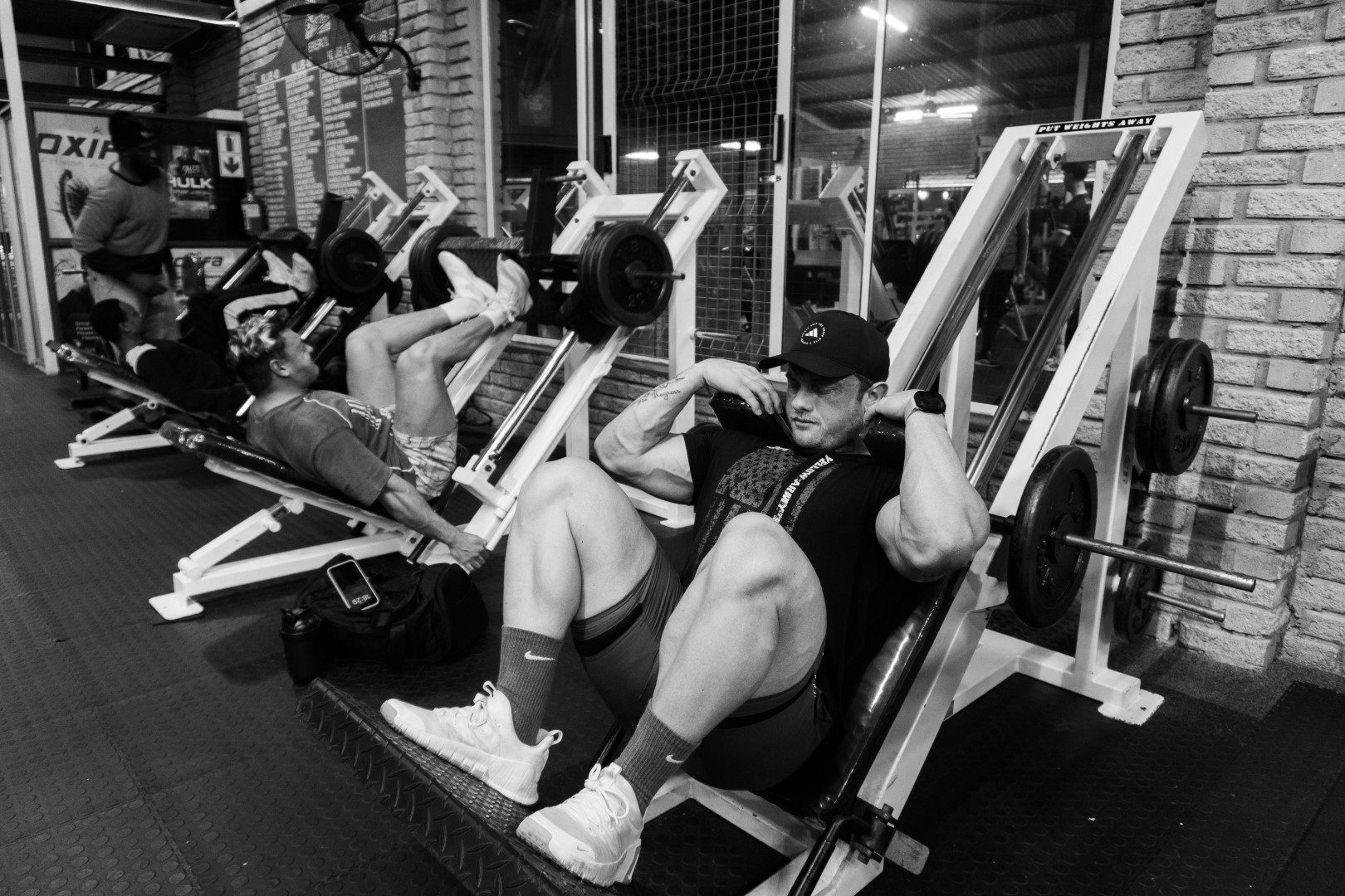 Multiple athletes training on leg press at Oxigim